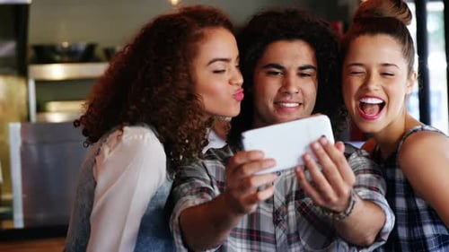 Friends Laughing and Looking at Mobile Phone Together