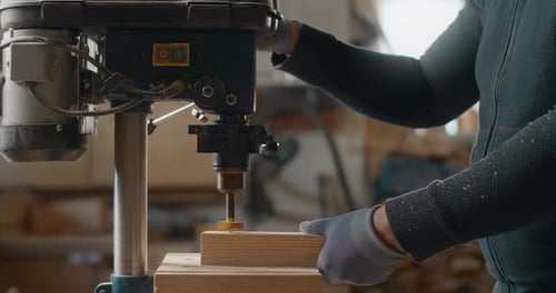 Carpenter Drills Holes in Wooden Plank with Drilling Machine in Slow Motion Carpentry at Workshop