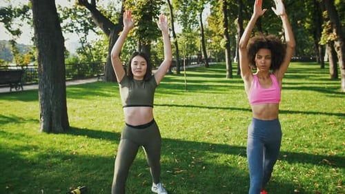 Women Doing Yoga in Green City Park