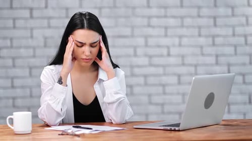 Stressed Woman at Desk with Laptop