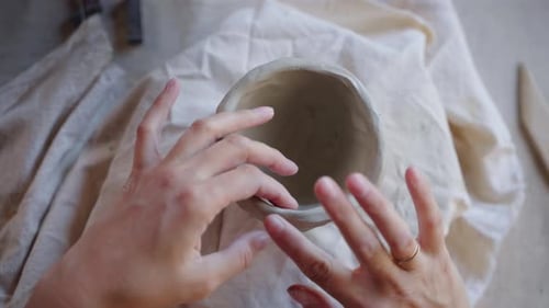 Hands Shaping Clay Into Small Ceramic Pot