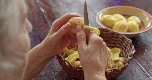 an Elderly Woman a Grandmother Peeling Potatoes in Her Country House the Handiwork of Old People
