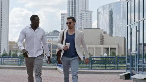 Two Colleagues Talking While Walking in the City