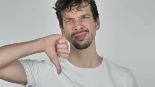 Portrait of Upset Young Casual Man Gesturing Thumbs Down
