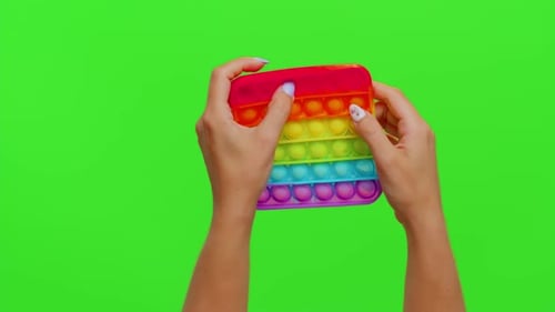 Closeup of Girl Hands Playing Squeezing Antistress Toys Simple Dimple Game Isolated on Chroma Key
