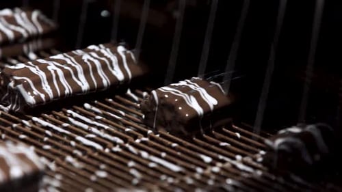Chocolate Bars Being Decorated on Conveyor Belt