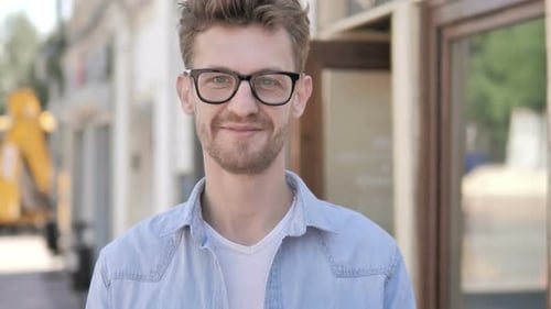 Jeune homme souriant à lunettes