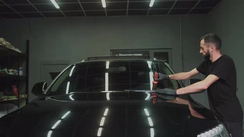 Professioneller Autokeramikarbeiter trägt eine Schicht Keramik-Schutzregen auf