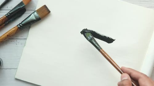 Zeichnen mit Kunstpinsel auf einem Papier