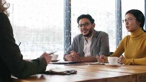Three Adults Meeting in Urban Workplace Cafe