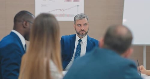 Diretor de uma empresa financeira ouve reunião de colegas e funcionários