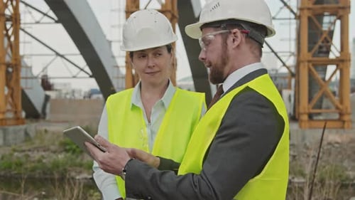Male Site Supervisor Discussing Work with Colleague