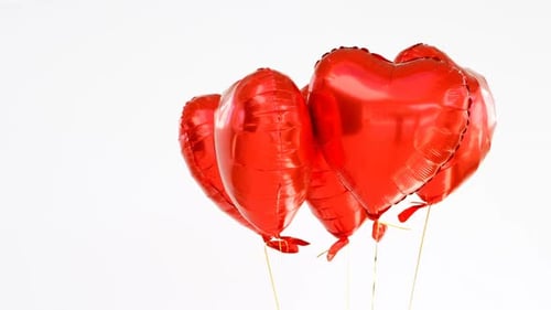 Red Heart Balloons Floating on White Background