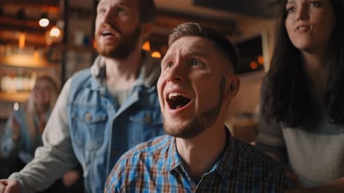 Portrait of a Bearded Male Fan Watching Football in a Bar with Friends