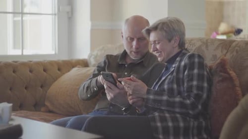 Couple Using Smartphone Together on Couch