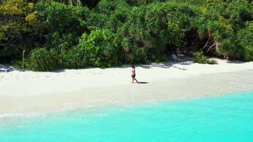 Beautiful happy lady on vacation in the sun on the beach on sunny blue and white sand 4K background