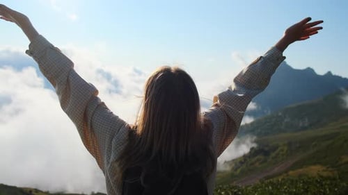 Woman Reaching the Mountain Top with Arms Outstretched