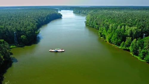 Ferry boat on the river transporting a car, aerial view