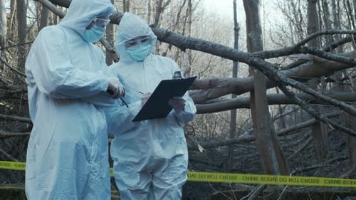 Forensic specialists working in the forest. Crime scene and police concept.