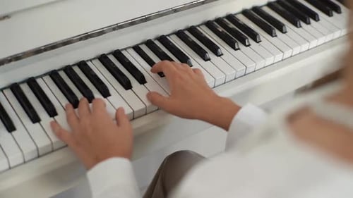 Closeup View From Shoulder of Unrecognizable Female Pianist Playing on Classical Piano at Home