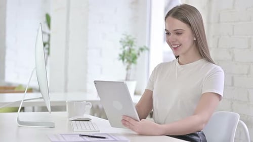 Young Woman Doing Video Chat on Tablet in Office