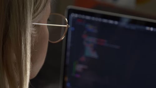 Woman developer coding on laptop computer. Close-up view face by side