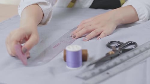 Person Marking Fabric with Ruler for Sewing