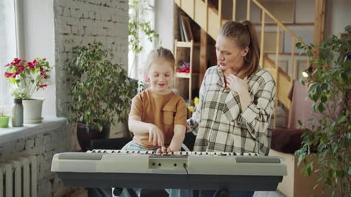 Young Girl Plays Keyboard With Woman
