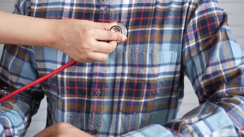 Doctor Using a Stethoscope Checking Body Close Up
