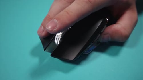 Man Turns Wheel of Optical Gaming Mouse on Bright Green