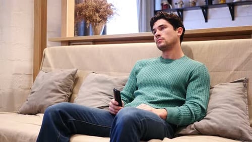 Young Man Watching Television, Changing Channels on Couch
