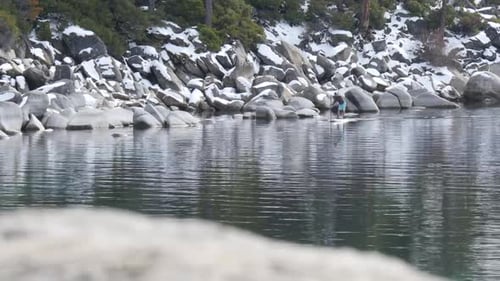 Person Stand Up Paddleboarding on Winter Lake