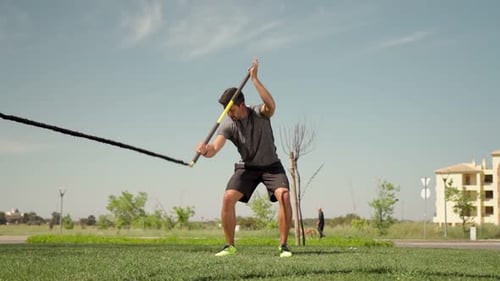 A Man of European Descent Trains with Aerobic Equipment Rubber Bands and Sticks From the Outside