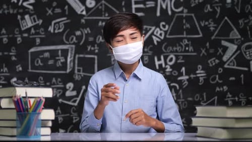 Person Explaining in a Classroom Wearing a Face Mask