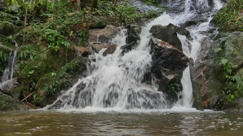 Waterfall Flowing Over Rocks in Tropical Forest