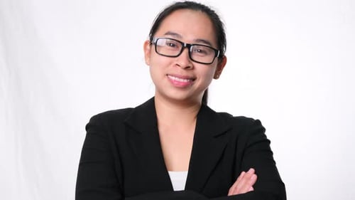 A happy and confident businesswoman standing with her arms crossed on white background.