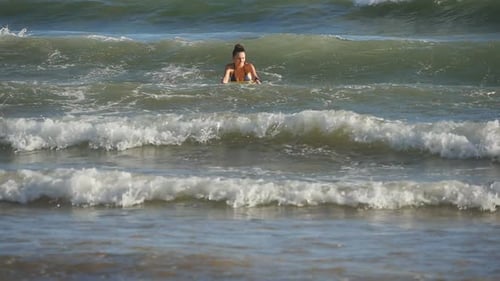 Beautiful Woman Swims at Ocean Waves on the Bodyboard During Summer Trip. Happy Young Girl Learns To
