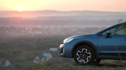 Woman Enjoying Sunrise Vista Next to Car