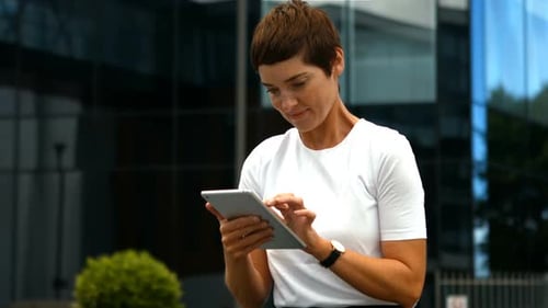 Woman Using Tablet Outside Modern Office Building