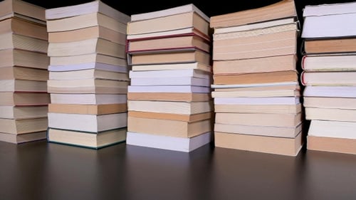 Stacks of Classic Books on Dark Glossy Table