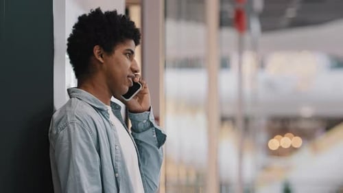 Side View African American Millennial 20s Business Man Male Guy Student Standing Near Wall in Public