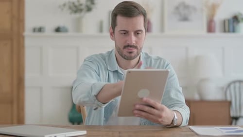 Young Man Reacting to Loss on Tablet in Office