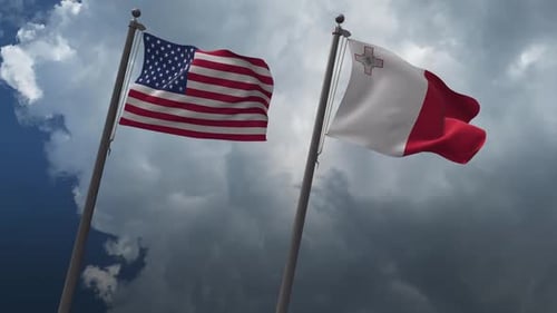 USA and Malta Flags Waving Together Against a Cloudy Sky