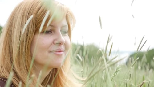 Outdoor relaxing female in the field slow-mo 1080p FullHD footage - Beautiful girl relaxing in the n