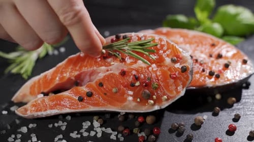 Salmon. Raw Trout Red Fish Steak with Herbs and Lemon and Olive Oil Rotated on Slate.