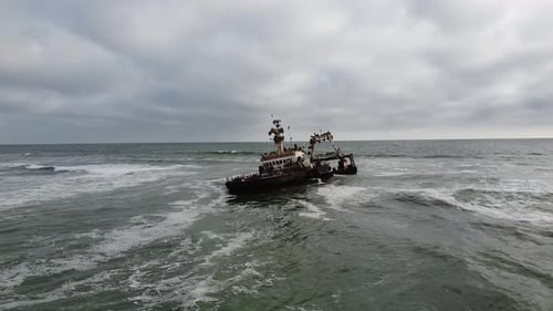 Barco hundido en el océano, barco oxidado espeluznante rodeado por el océano ondulado