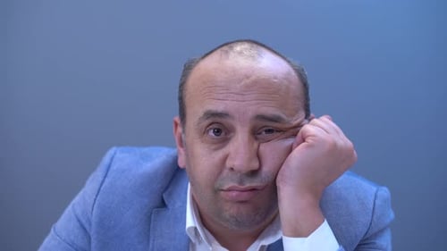 Bald man taking off wig.