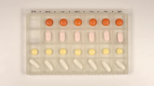 Pills Being Taken Out of Organizer