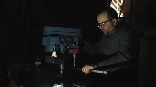 Bearded Man Using a Drill Press in Workshop