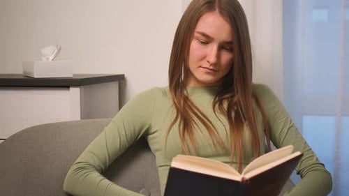 Woman Reading a Book on Couch in Living Room
